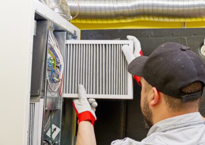 Technician replacing an air filter in an hvac unit.